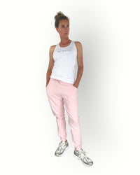 Pink joggers with zippers at the legs and side pockets super soft fabric and the model wears a white tanktop