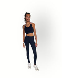 Woman wearing a black athletic outfit on a white background